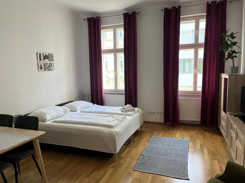 a bedroom with a bed and two windows at Casa Nostra - Helle Wohnung - direkt am Augarten in Vienna