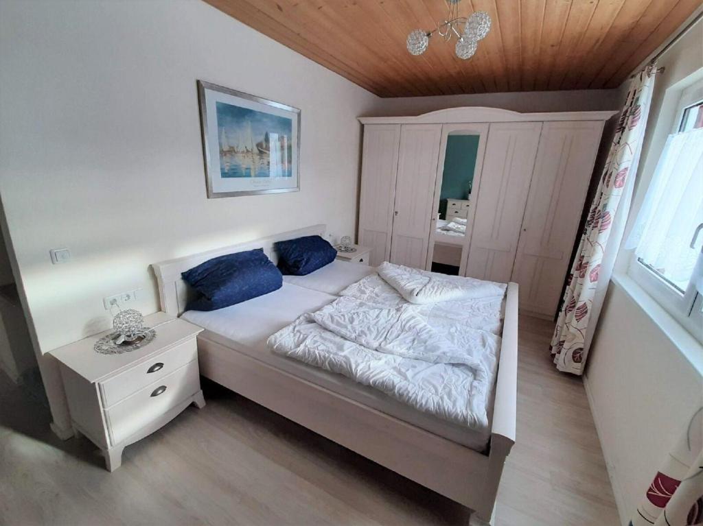 ein Schlafzimmer mit einem Bett mit blauen Kissen in der Unterkunft Feriendorf Reichenbach - Dachspfad 6 in Nesselwang