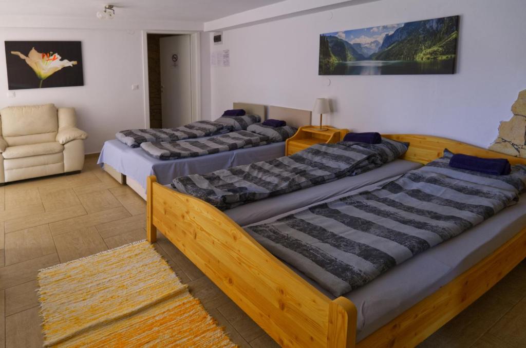 3 camas en una habitación con sofá y silla en Chill House en Orfű