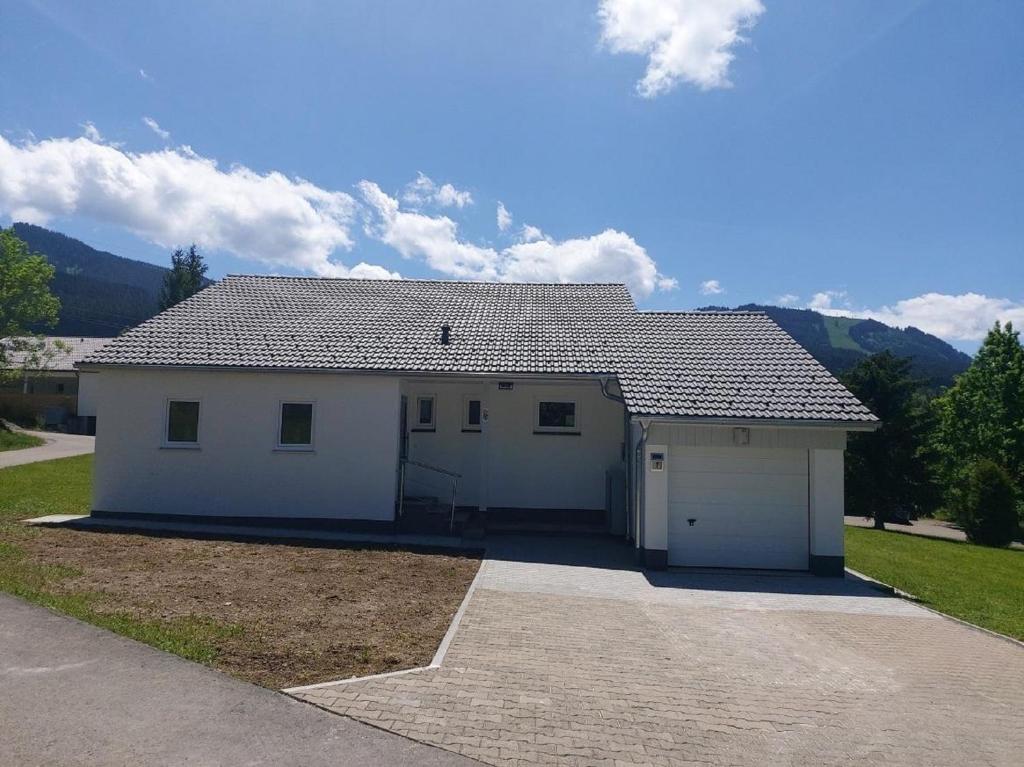 a large white garage with a roof at Feriendorf Reichenbach - Dachspfad 7 in Nesselwang