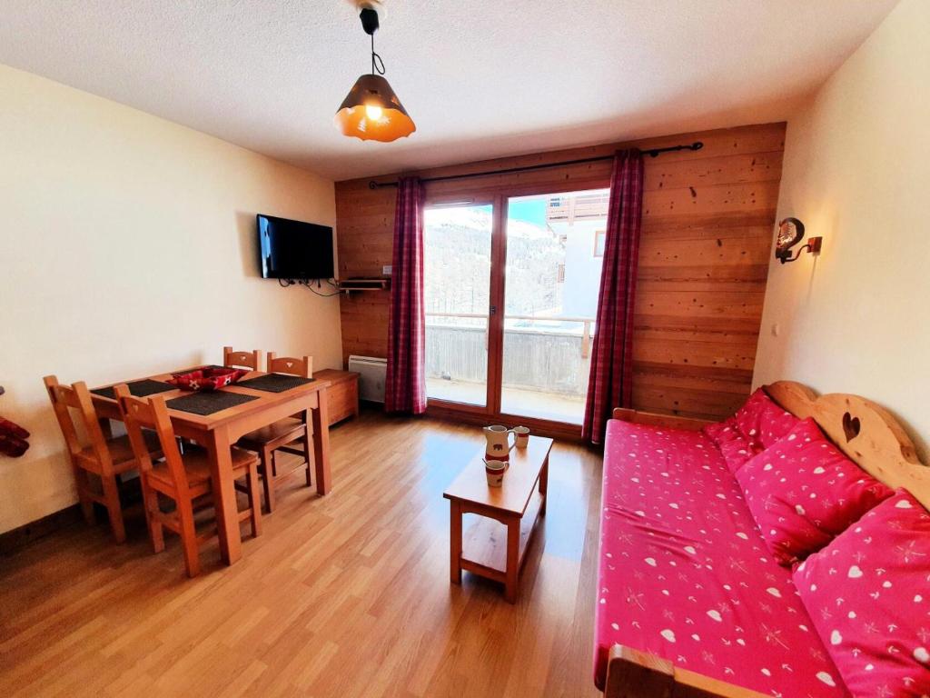 ein Wohnzimmer mit einem Sofa und einem Tisch in der Unterkunft Les Chalets Des Rennes - 2 Pièces pour 4 Personnes 744 in Vars