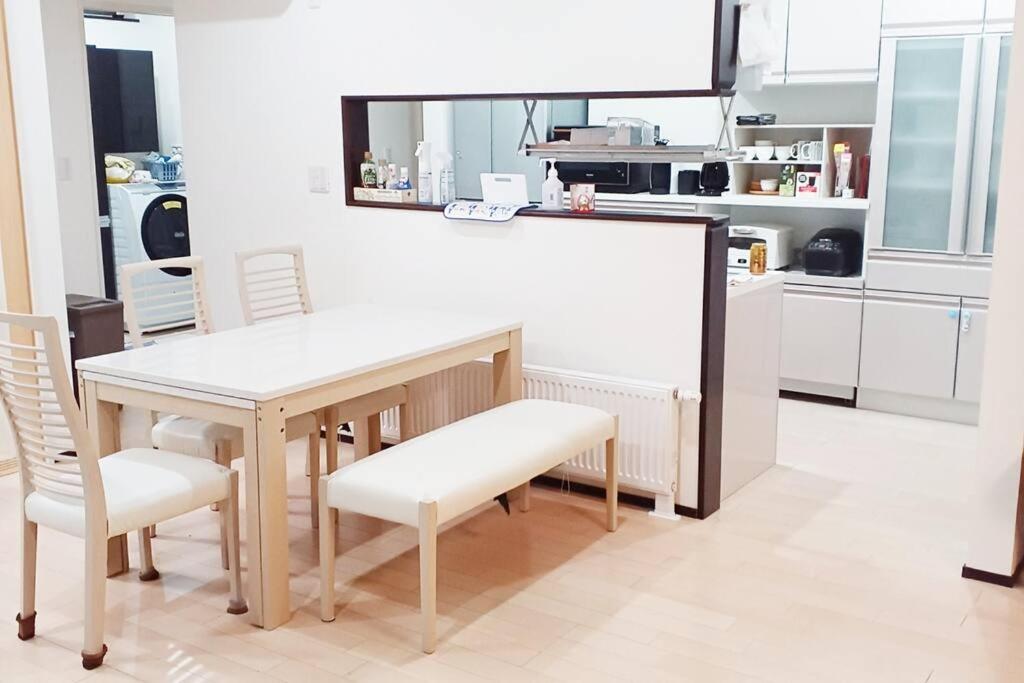 cocina con mesa, sillas y barra en アンドステイ上士幌 en Kami-shihoro