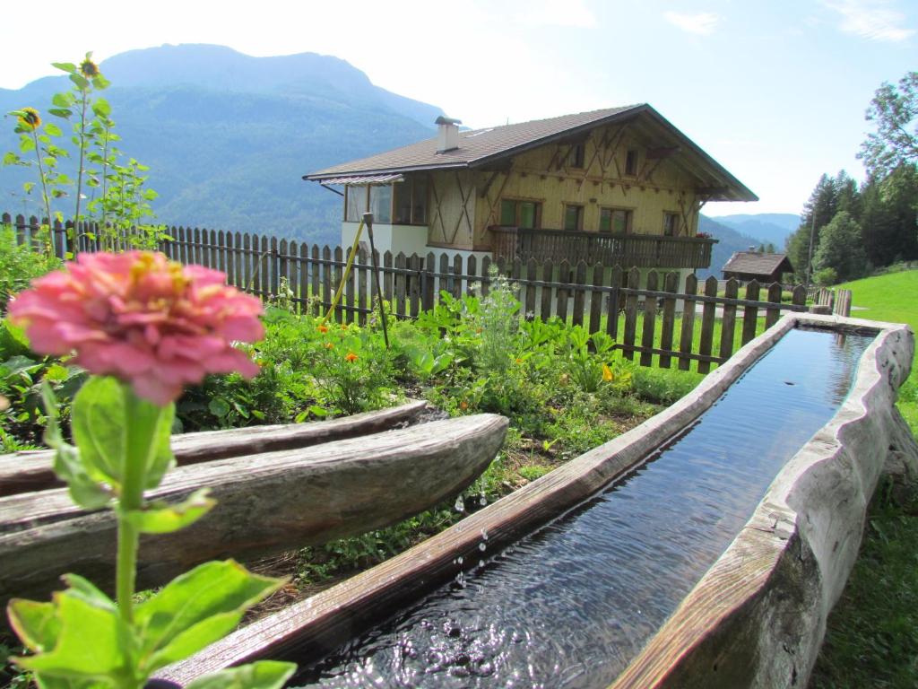a garden with a water feature in front of a house at Oeberst-hof in Sarntal