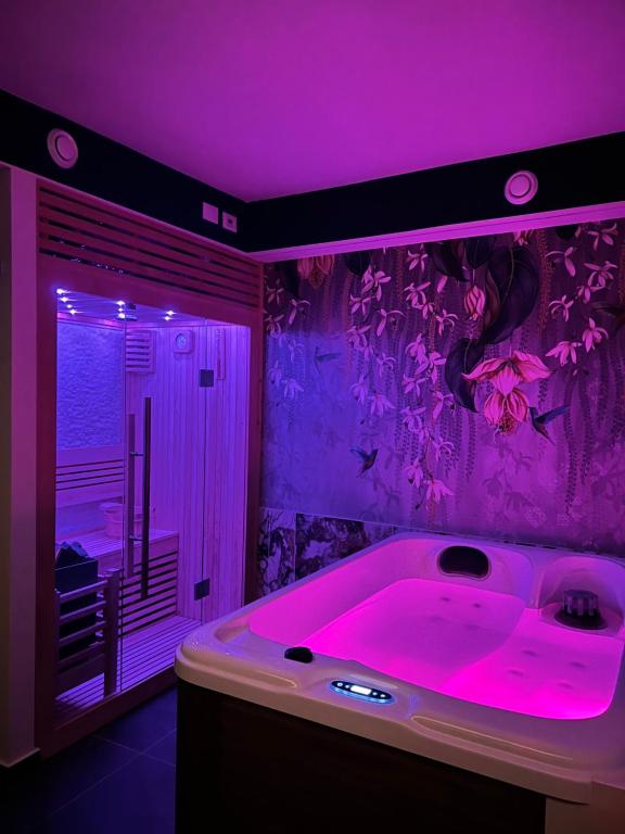 a bathroom with a tub with a purple lighting at Marcello Sleep&Spa in Verona