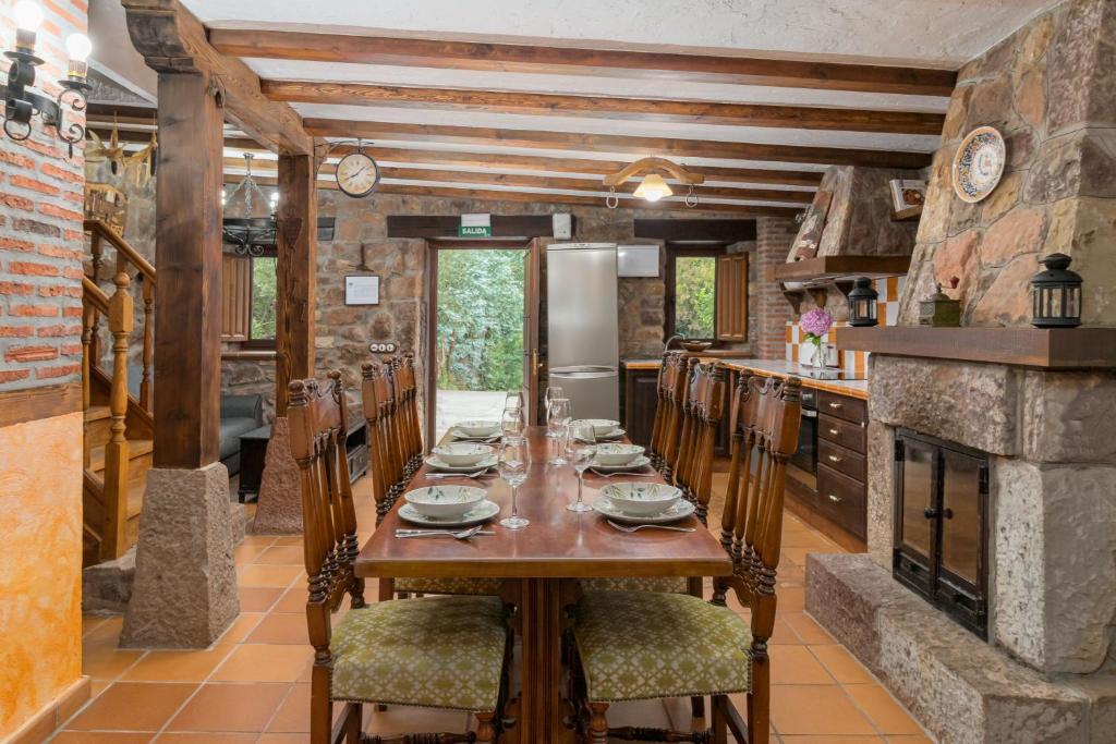 uma sala de jantar com uma mesa de madeira e cadeiras em Senda del pasiego em Liérganes