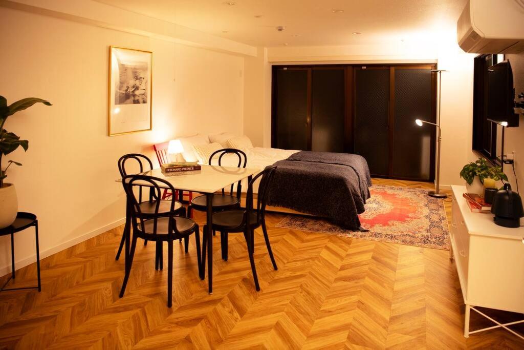 a bedroom with a bed and a table and chairs at #5 3stops to Shinjuku station stylish spacious studio apartment in Tokyo