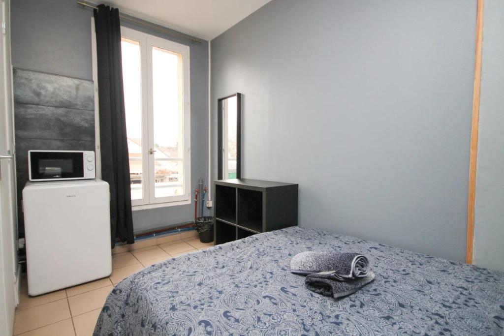 um quarto com uma cama com um par de sapatos em 02 Chambre avec lit double et sdb privé Wifi em Saint-Denis