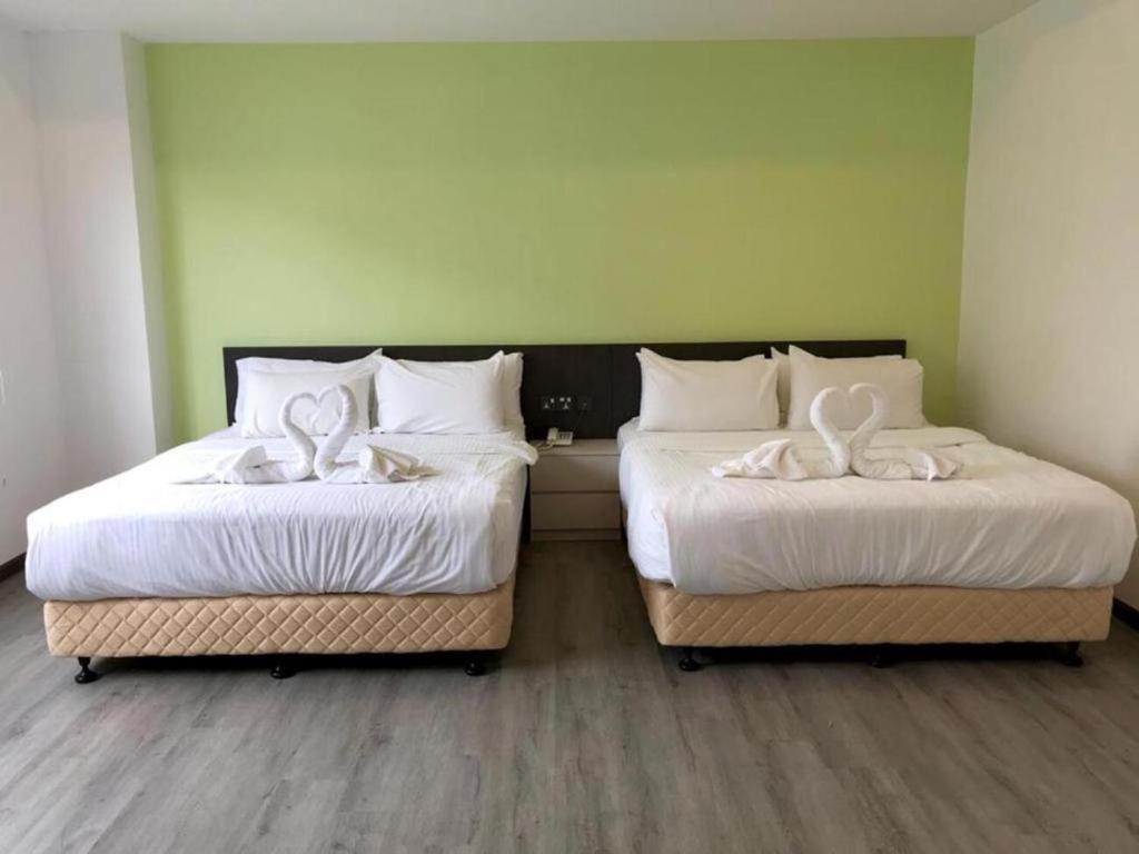 Postel nebo postele na pokoji v ubytování TT Dorf Hotel Taiping