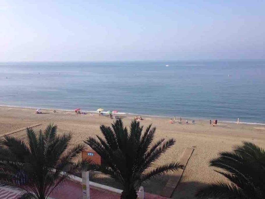 una spiaggia con palme e persone in acqua di Ocean Views a Almería