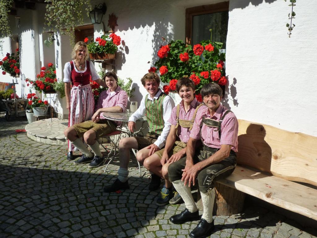 a group of people sitting on a bench in front of a building at Fenzhof in Schladming
