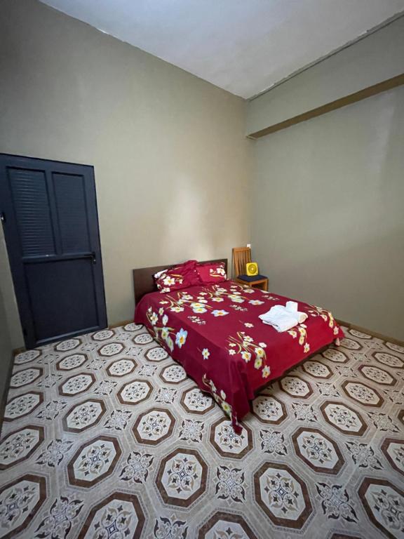 een slaapkamer met een bed met een rood dekbed bij Riambel Paradise Inn Room 3 in Riambel