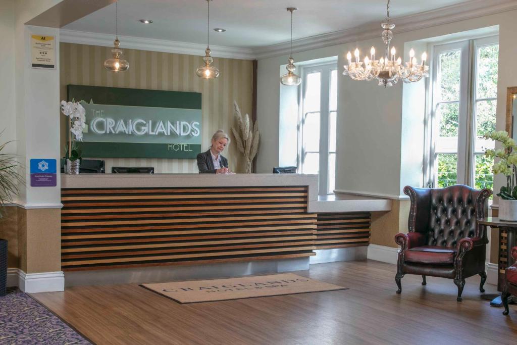 a woman standing at a counter in a lobby at The Craiglands Hotel Sure Hotel Collection by Best Western in Ilkley