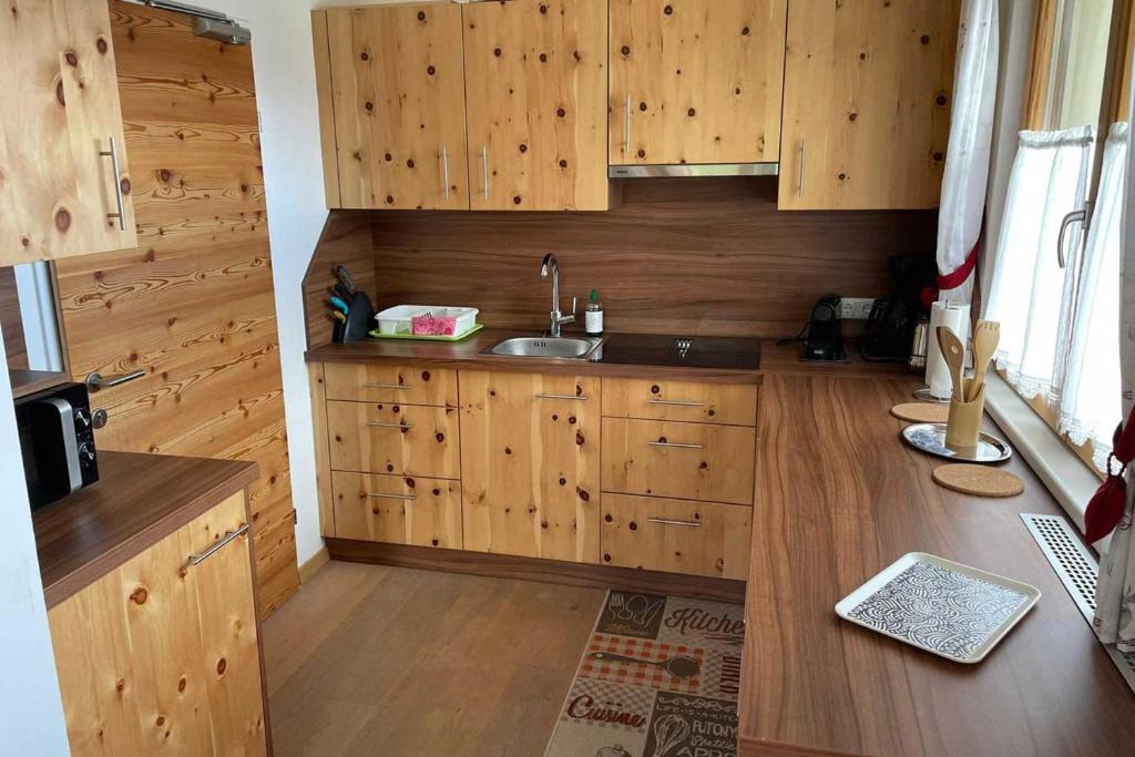 una cucina con armadi in legno e lavandino di Wohnung Habicht 146 - Naviser Huette a Navis