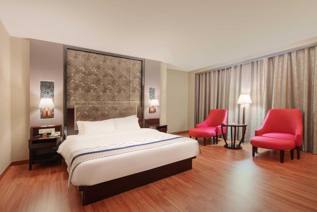 Postel nebo postele na pokoji v ubytování Foshan Guanxin Hotel