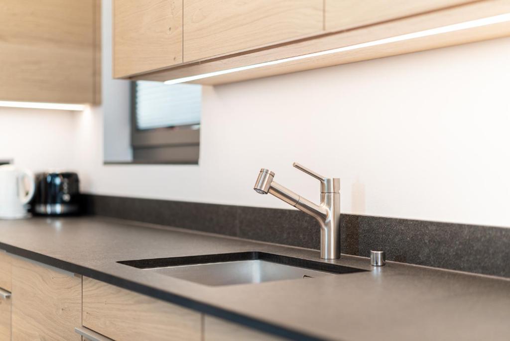 una encimera de cocina con fregadero en una cocina en Haus Beta by Zermatt Premium Apartments, en Zermatt