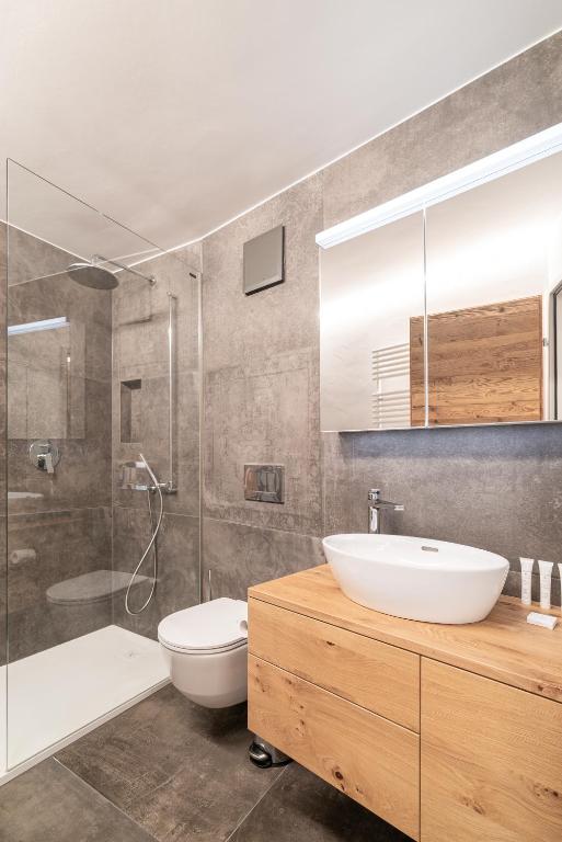 Un baño con lavabo, inodoro y ducha. en Haus Beta by Zermatt Premium Apartments, en Zermatt