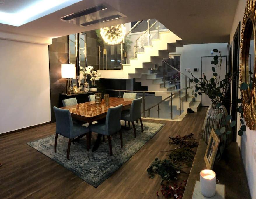 a dining room with a table and chairs and a staircase at Valadares House in Corroios