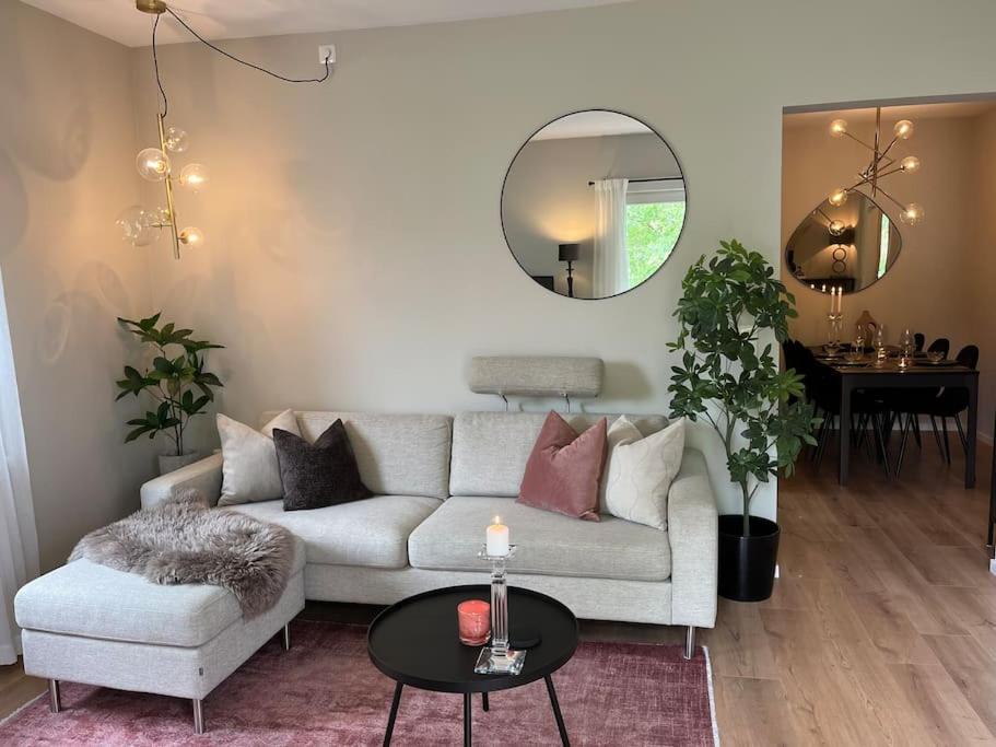 a living room with a white couch and a round mirror at Stylish 3-room apartment with balcony and free parking in Oslo