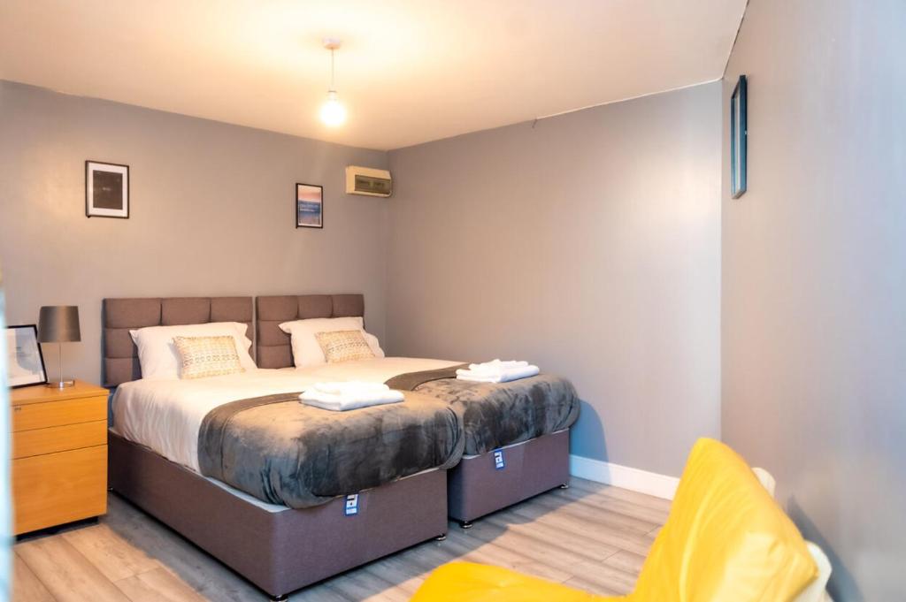 a bedroom with a large bed and a chair at Eastville Superb Dwelling, sleeps up to 4 guests in Bristol