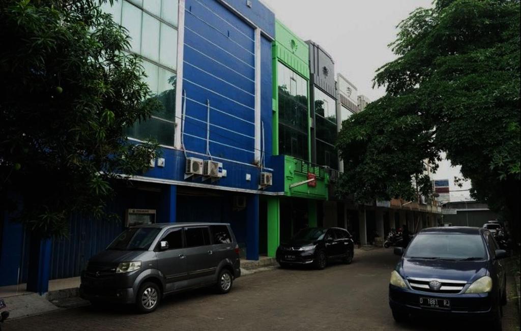 two cars parked in front of a building at OYO Life 92878 Kost Padma Syariah in Kandang-besar