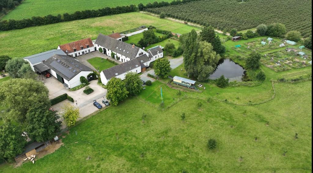 une vue aérienne sur une grande maison dans un champ dans l'établissement Ferme du Grand-Spinois, à Rebecq-Rognon