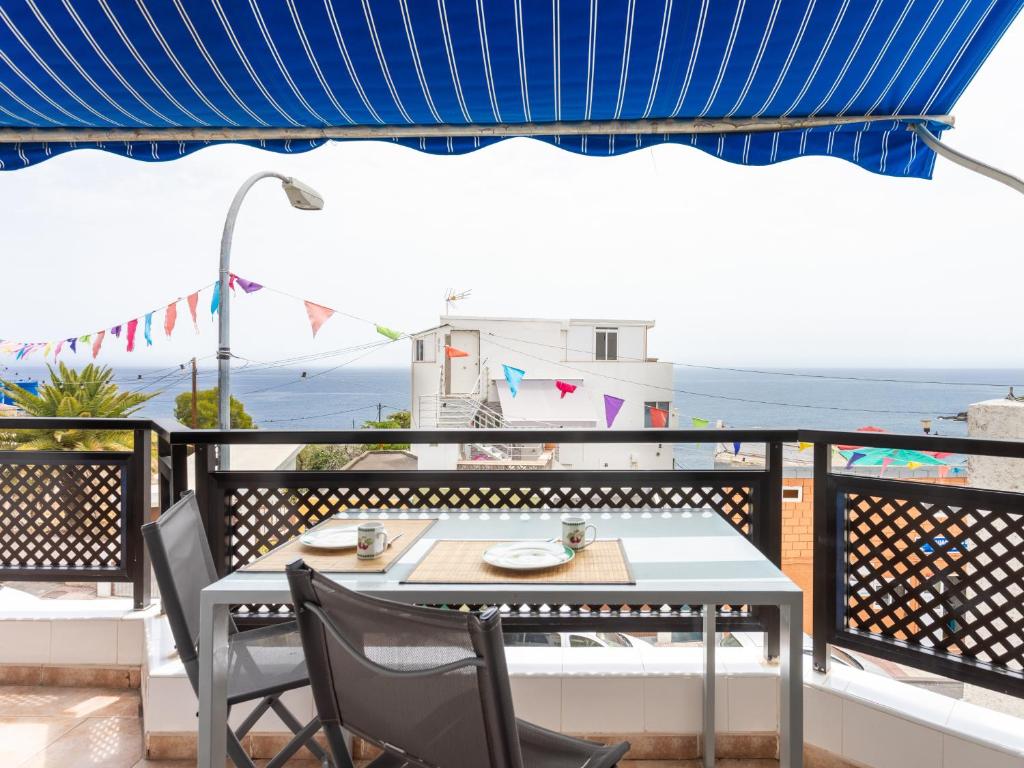 Araya的住宿－Live Caletillas Garoe con Terraza piso familiar，海景阳台上的桌椅