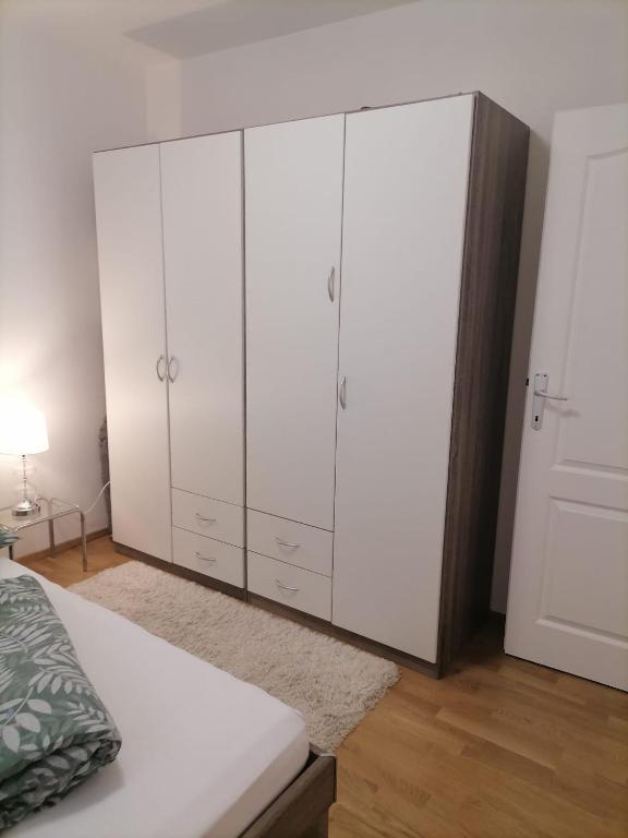a bedroom with white cabinets and a bed at Airport Apartment in Surčin