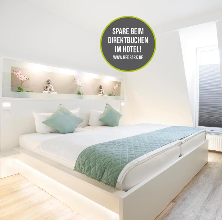 a white bedroom with a large white bed with green sheets at bedpark Stellingen in Hamburg