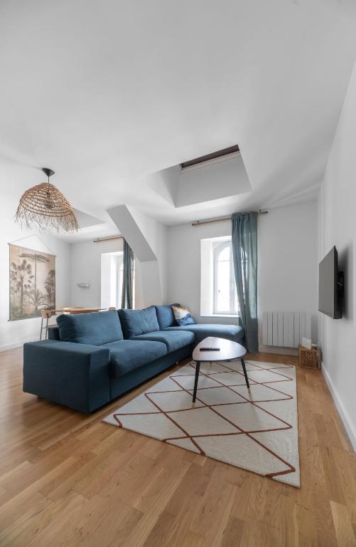 a living room with a blue couch and a table at Le Wilson - Appartement design - Hyper centre in Vichy