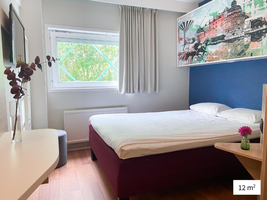 a hotel room with a bed and a window at Good Morning Örebro in Örebro