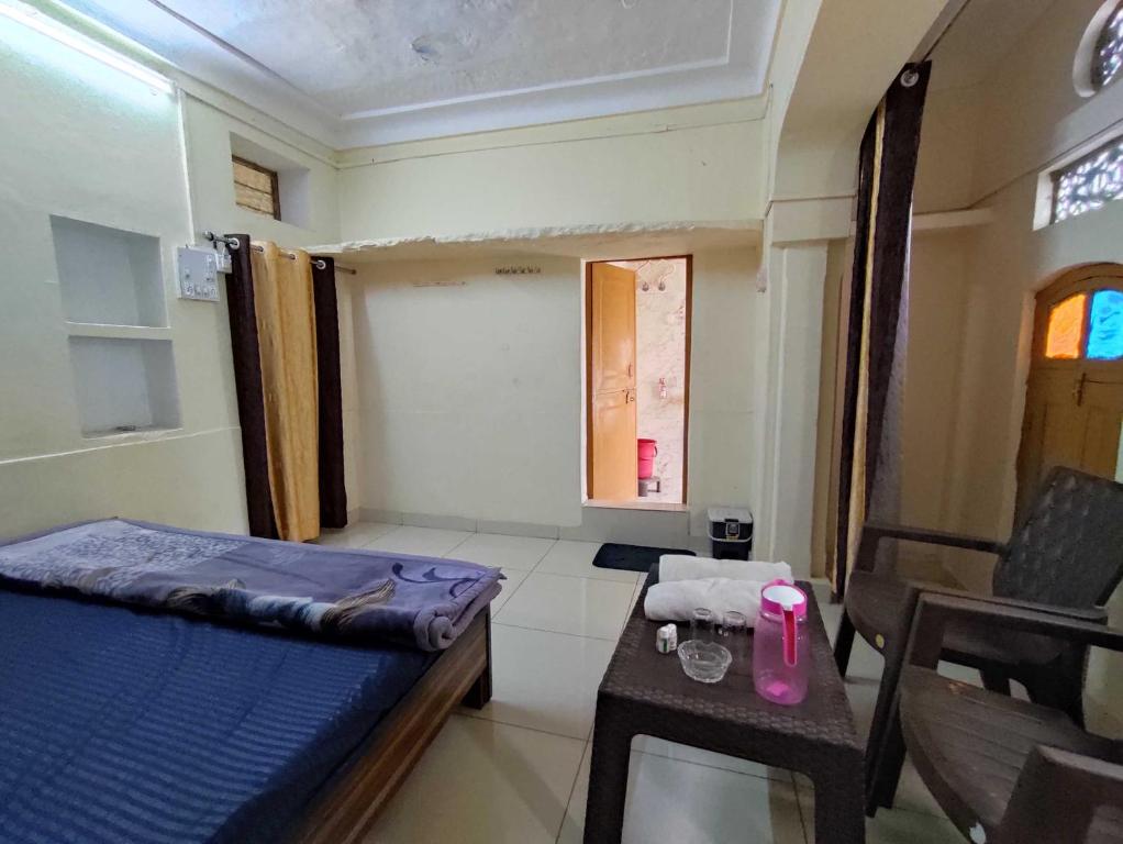 Cette chambre comprend un lit et une table avec une bougie rose. dans l'établissement OYO Ambika Guest House, à Pushkar