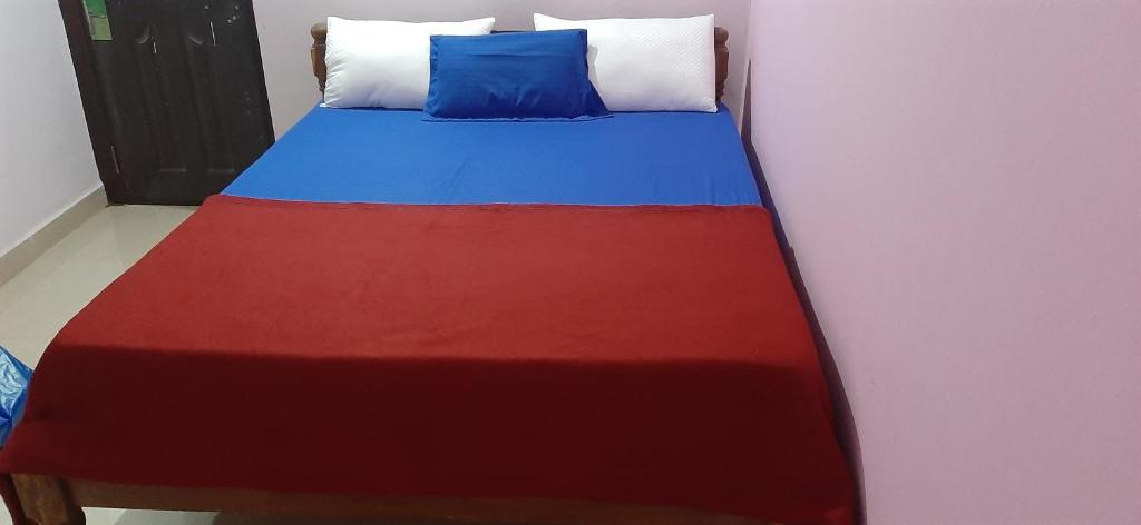 un letto con una coperta rossa e blu sopra di Pihu guest house a Calangute