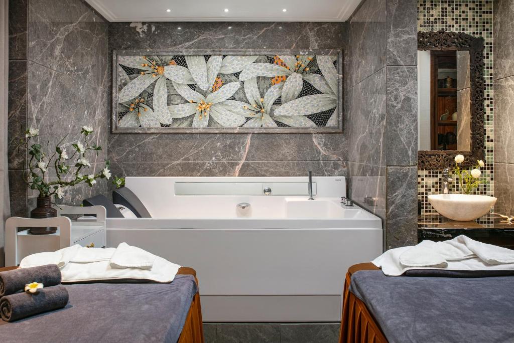 a bathroom with a bath tub and a sink at Lucien Hanoi Lakeside Hotel & Rooftop in Hanoi