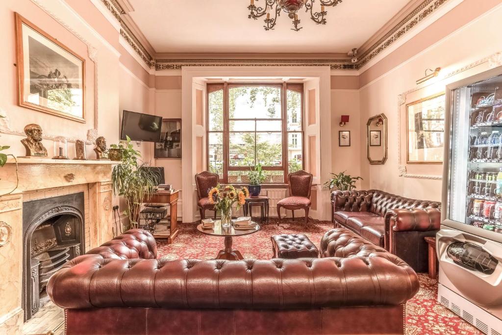 uma sala de estar com mobiliário de couro e uma lareira em Dolphin Hotel em Londres