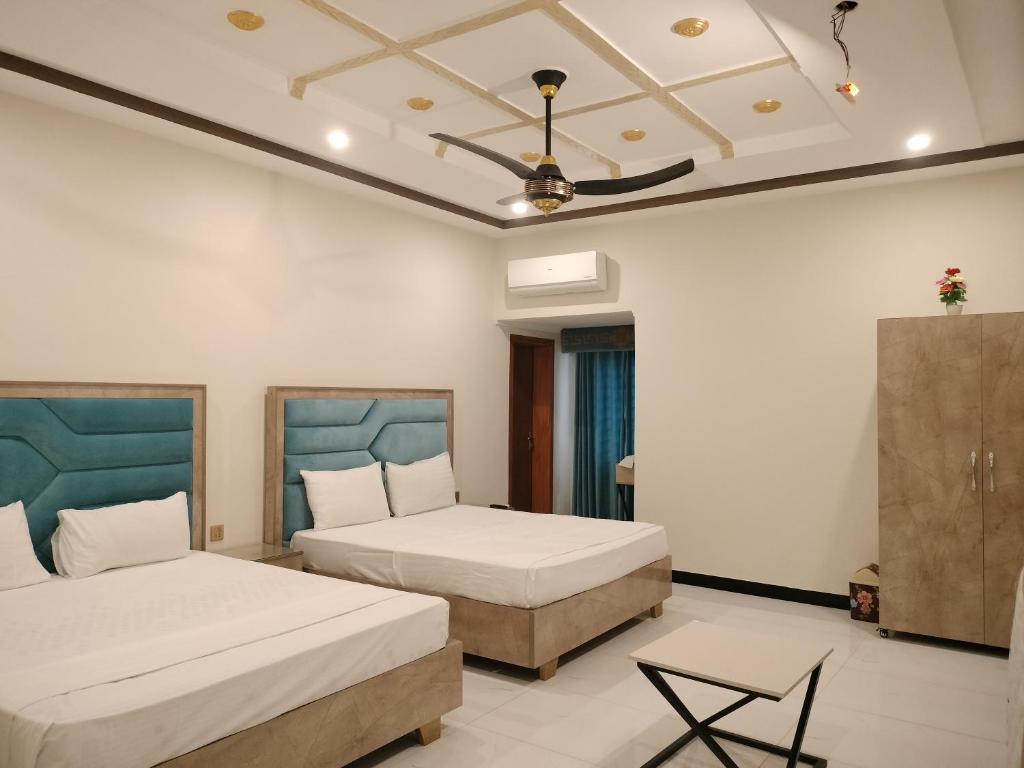 1 dormitorio con 2 camas y techo en Dove Inn Hotel en Lahore