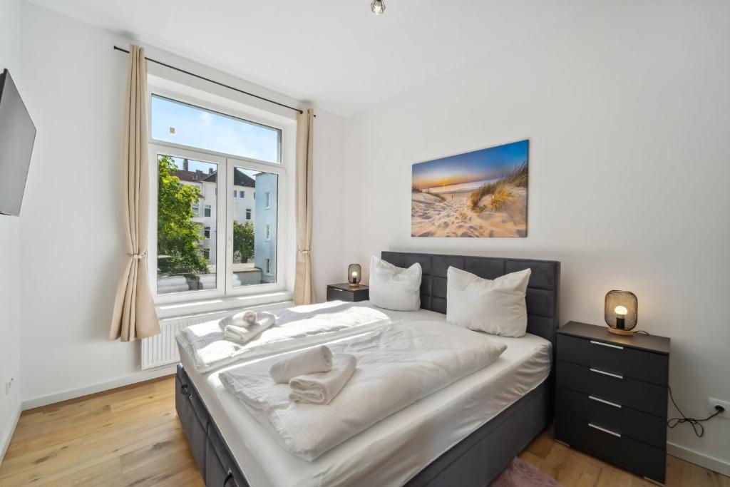 Un dormitorio con una cama grande y una ventana en Infinity Stay: Ferienappartments Rheinstrasse, en Wilhelmshaven