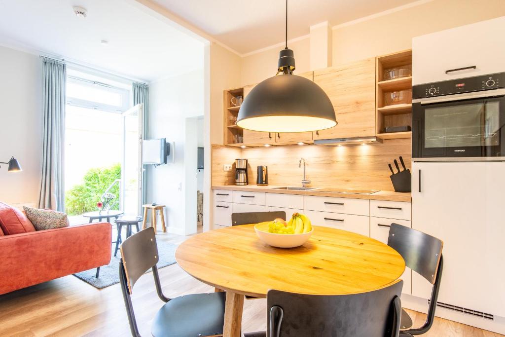 a kitchen with a wooden table with a bowl of fruit on it at Steger-Hüs Wohnung 02 in Rantum