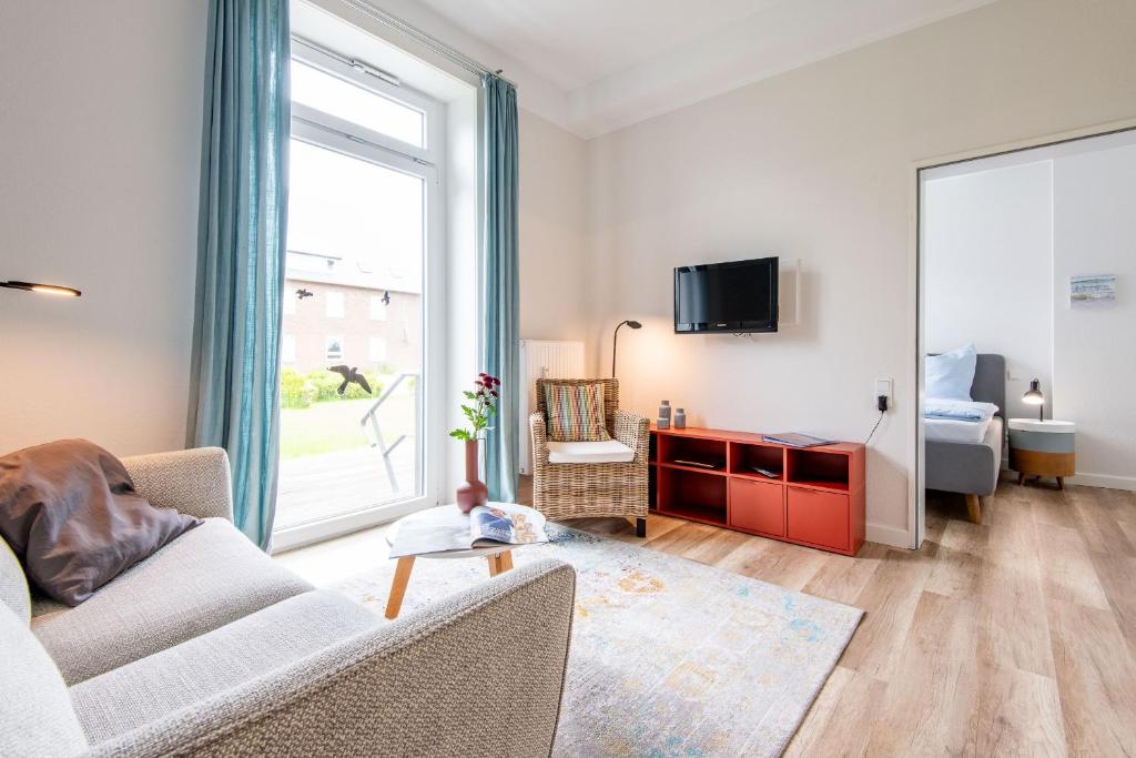 a living room with a couch and a large window at Steger-Hüs Wohnung 05 in Rantum