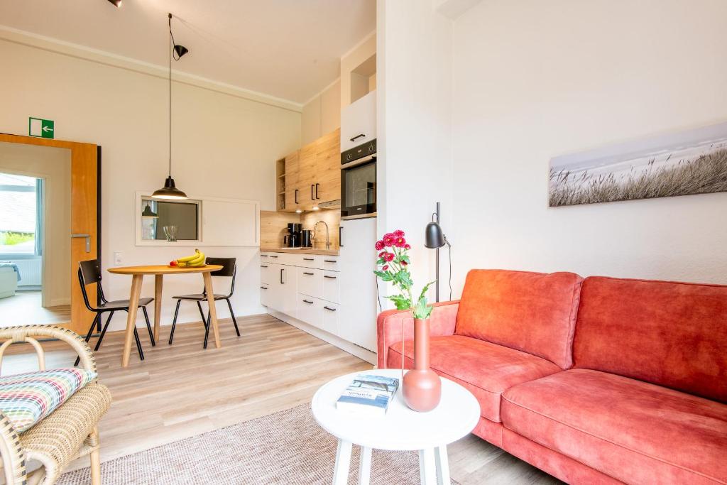 a living room with a red couch and a table at Steger-Hüs Wohnung 10 in Rantum