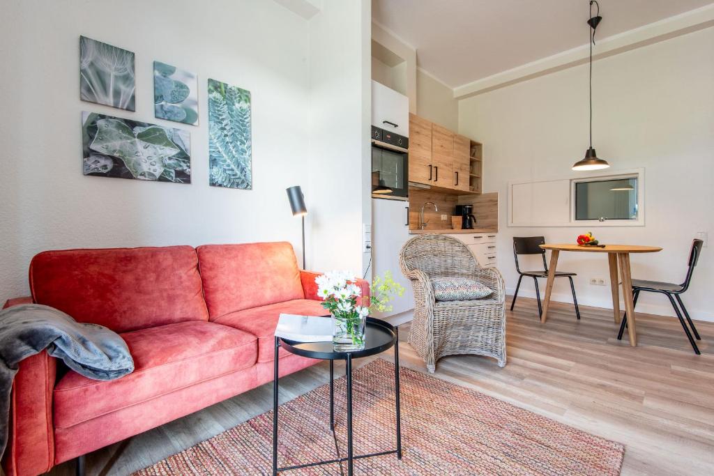 a living room with a red couch and a table at Steger-Hüs Wohnung 13 in Rantum
