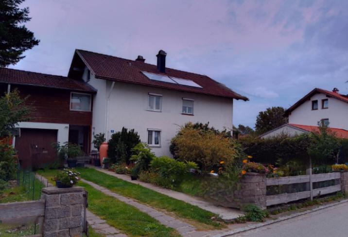 una casa blanca con una valla delante en Haus am Bach ausschließlich für Familien !!!!, en Unterthingau