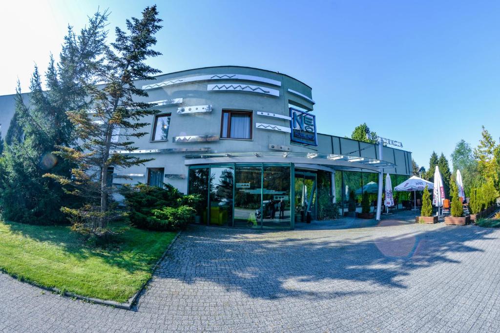 un grand bâtiment avec un arbre en face dans l'établissement Hotel Neo, à Tarnowskie Góry