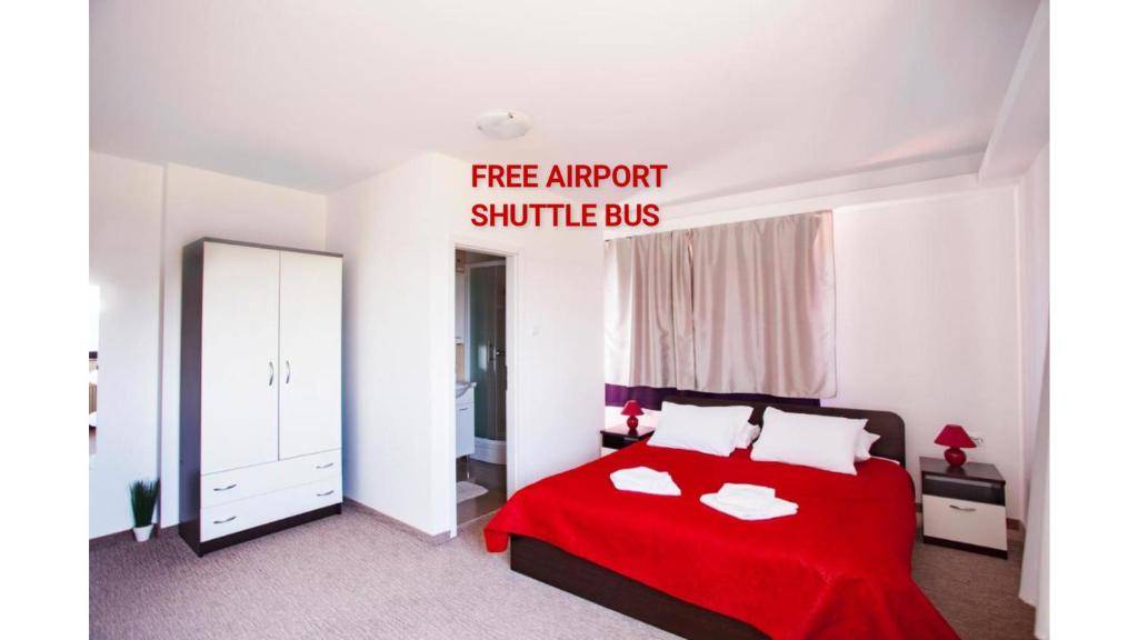 a bedroom with a red bed with a fire attempt shuttle bus sign at London Rooms Zagreb Airport in Velika Gorica