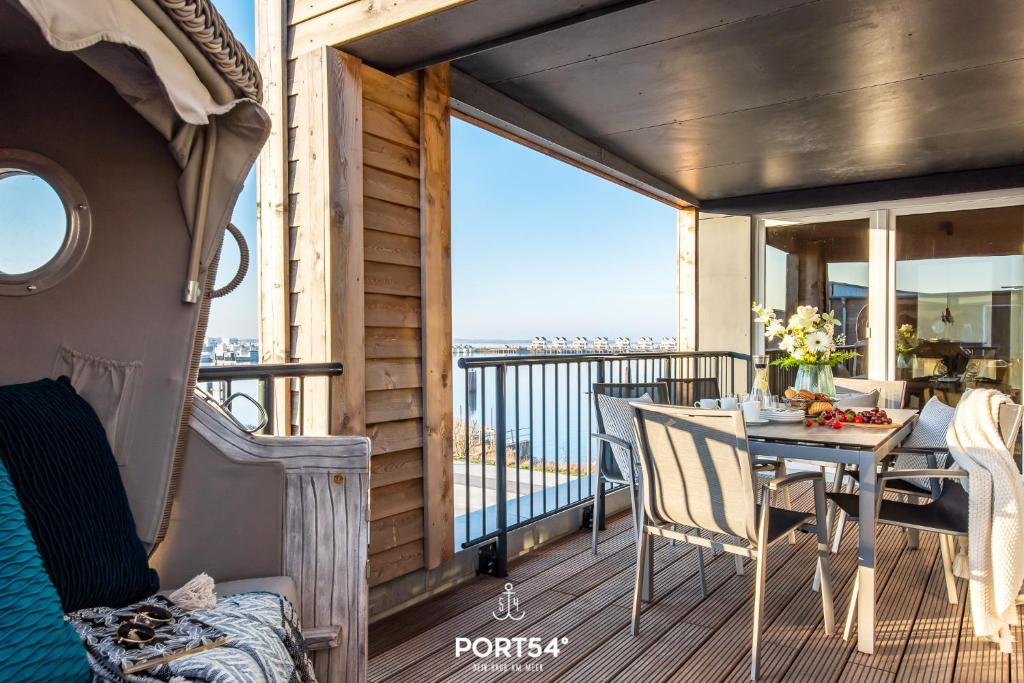 une chambre avec un balcon avec une table et des chaises dans l'établissement Hafen Loft, à Olpenitz