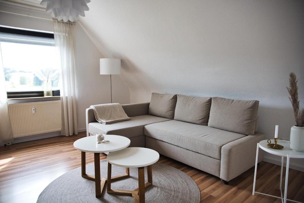 a living room with a couch and two tables at DG-Wohnung mit sonnigem Balkon in Marburg an der Lahn