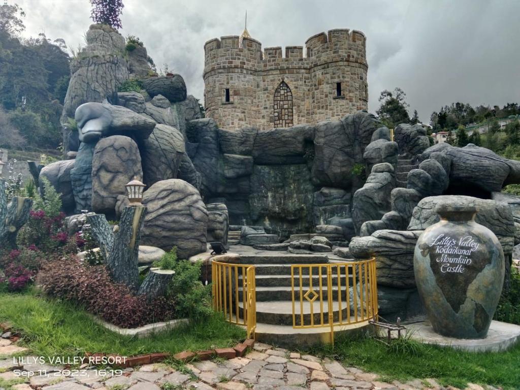 een kasteel op de top van een berg met een poort bij Lilly's Valley Resort in Kodaikānāl
