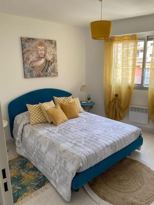 - une chambre dotée d'un lit bleu et d'une peinture murale dans l'établissement Menton Karma - Parking & Terrace, à Menton