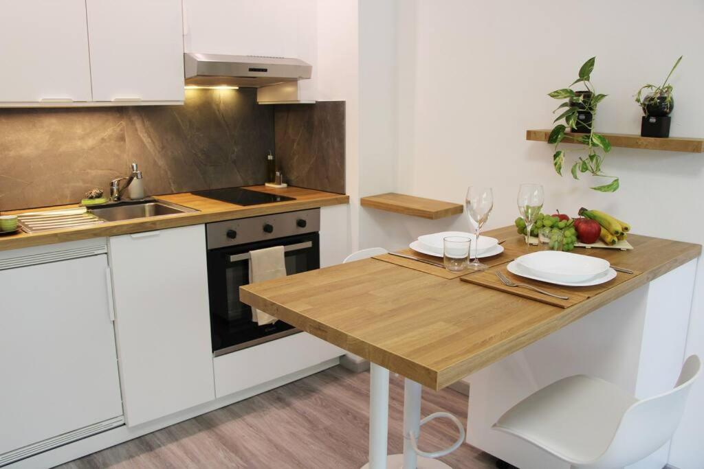 une cuisine avec une table en bois et des plaques de cuisson. dans l'établissement Lovely Studio with Free Parking!, à Lugano
