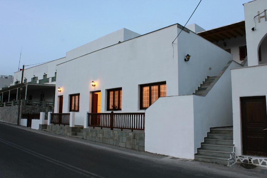 una casa blanca con escaleras al lado de una calle en Violetta, en Ios Chora