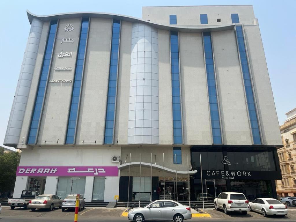 un edificio con coches estacionados frente a él en جلنار الشرق للشقق المخدومة, en Yeda